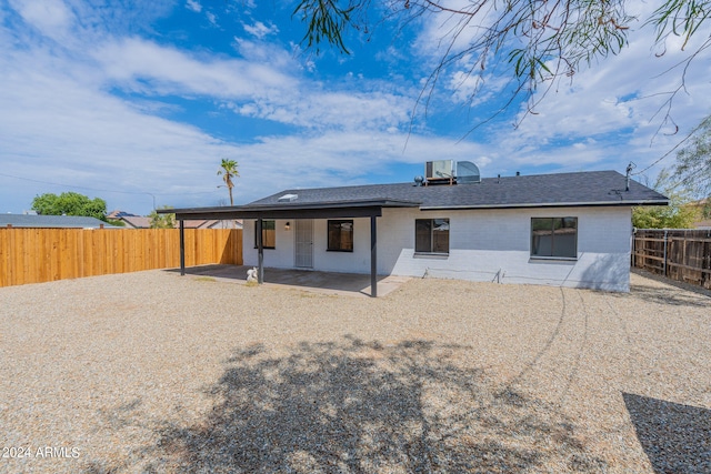 rear view of house with central air condition unit and a patio