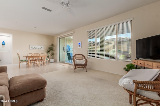 carpeted living room with ceiling fan