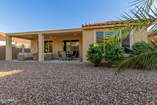 back of property featuring ceiling fan, a patio area, and outdoor lounge area