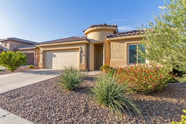 7790 W Noble Prairie Way, Florence, AZ 85132 - mediterranean / spanish-style house with a garage, driveway, a tiled roof, and stucco siding