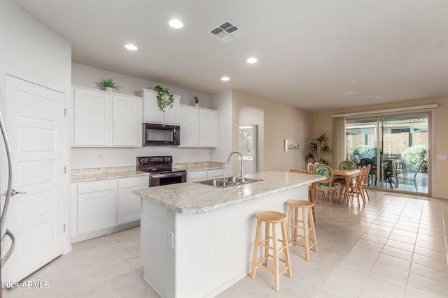 kitchen with white cabinetry, black appliances, sink, and a kitchen island with sink