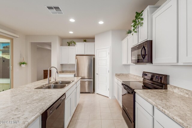 kitchen featuring white cabinets, light tile patterned floors, light stone countertops, black appliances, and sink