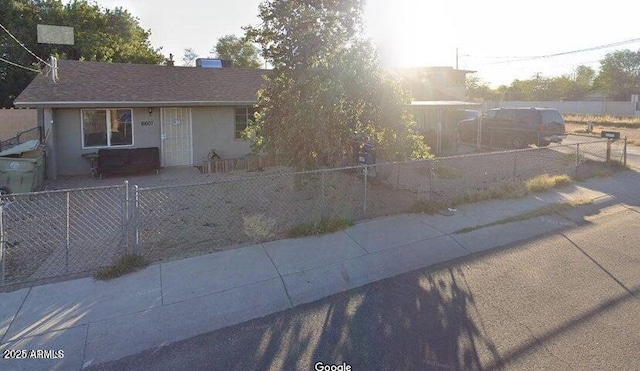 view of front of property with a fenced front yard and roof with shingles