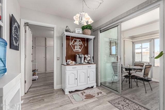 dining area featuring light wood-type flooring, baseboards, and a notable chandelier