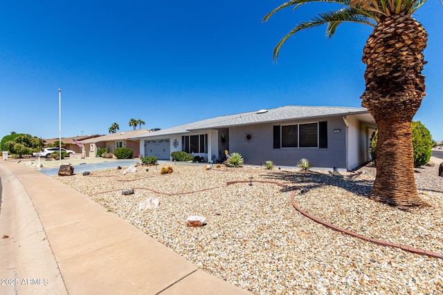 ranch-style house with an attached garage, driveway, and brick siding