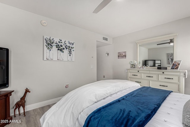 bedroom featuring baseboards, visible vents, light wood-style floors, and ceiling fan