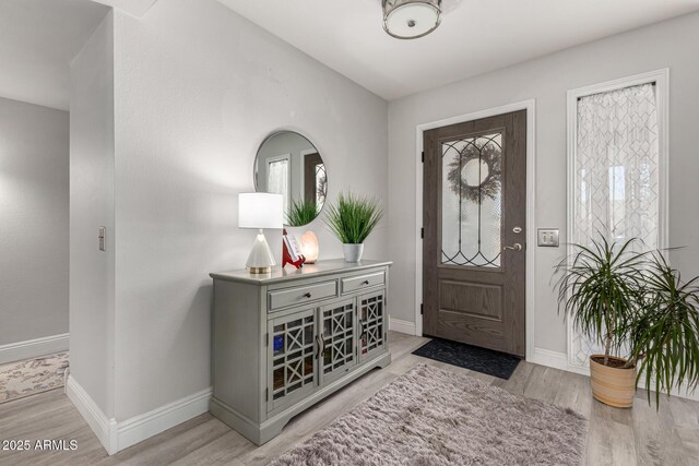 foyer entrance featuring light wood-style flooring and baseboards
