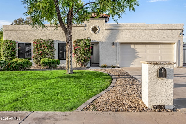 view of front of property with a front lawn and a garage