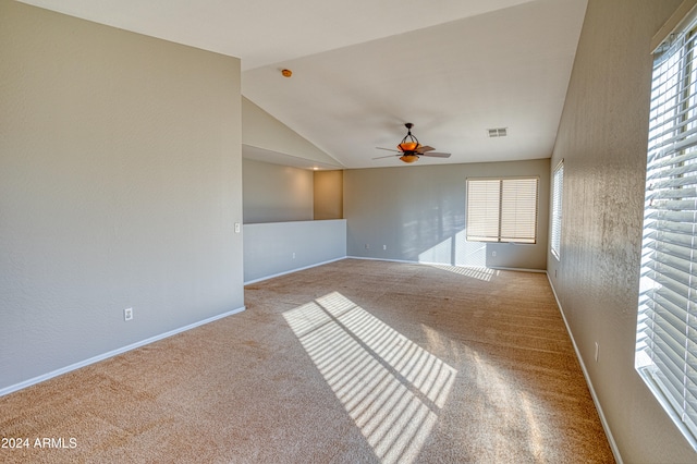 carpeted empty room featuring vaulted ceiling and ceiling fan