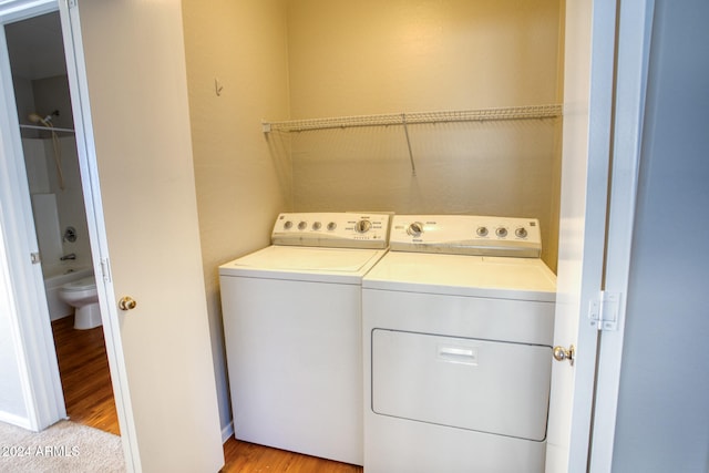 laundry area featuring washer and dryer and light hardwood / wood-style floors