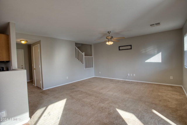 interior space with light carpet and ceiling fan