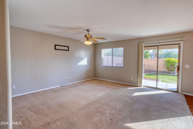 carpeted spare room featuring ceiling fan