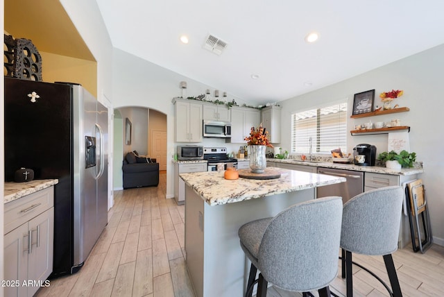 11207 W Turney Ave, Phoenix, AZ 85037 - kitchen with stainless steel appliances, a kitchen island, vaulted ceiling, a sink, and arched walkways