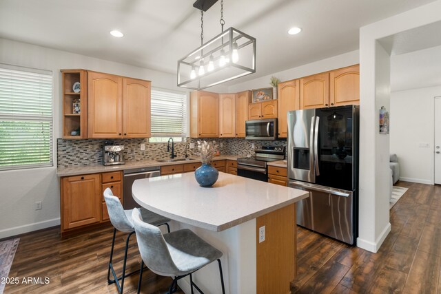 1812 E Parkside Ln E, Phoenix, AZ 85024 - kitchen featuring appliances with stainless steel finishes, tasteful backsplash, dark wood-style flooring, a breakfast bar area, and recessed lighting