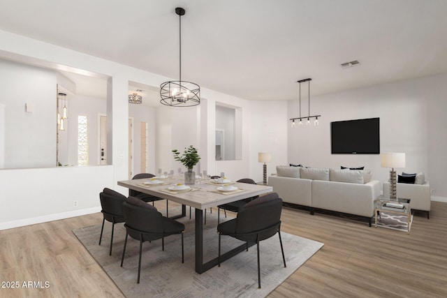 dining room with baseboards, visible vents, and wood finished floors