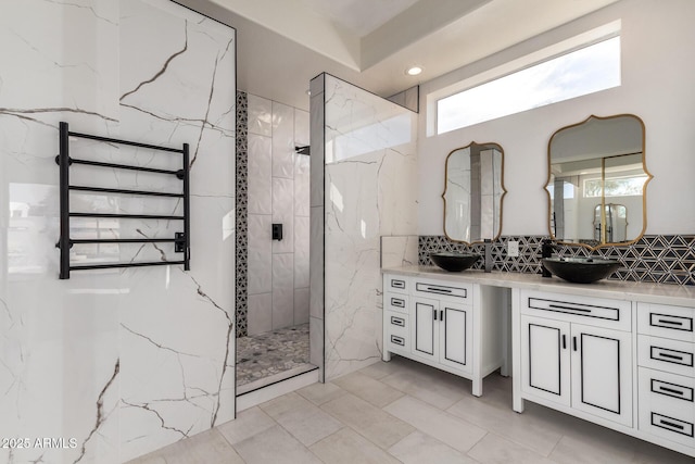 full bathroom featuring a sink, backsplash, a marble finish shower, and double vanity