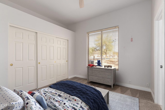 bedroom featuring carpet floors, a closet, baseboards, and a ceiling fan