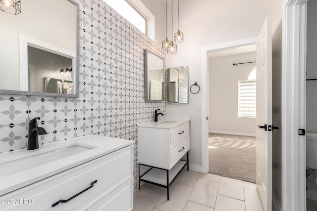 bathroom with two vanities, a sink, tile walls, and tile patterned floors