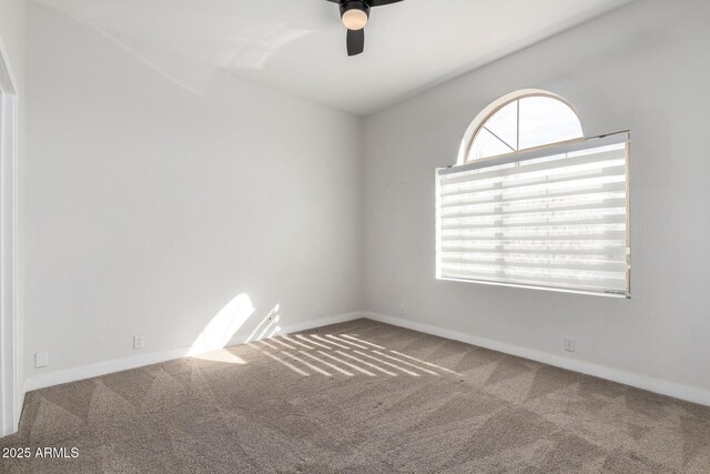carpeted spare room featuring a ceiling fan, plenty of natural light, and baseboards