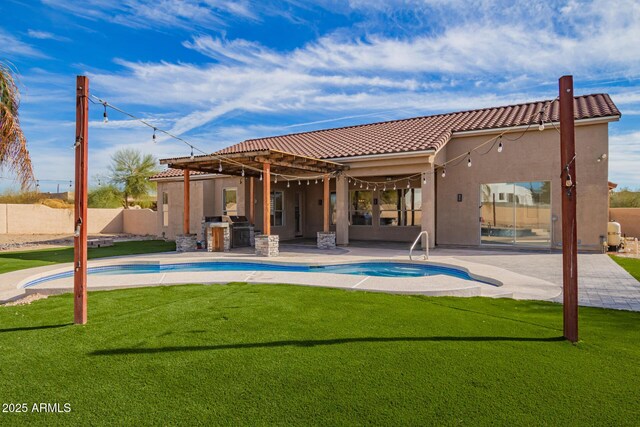 rear view of house featuring a fenced in pool, fence, exterior kitchen, and a patio