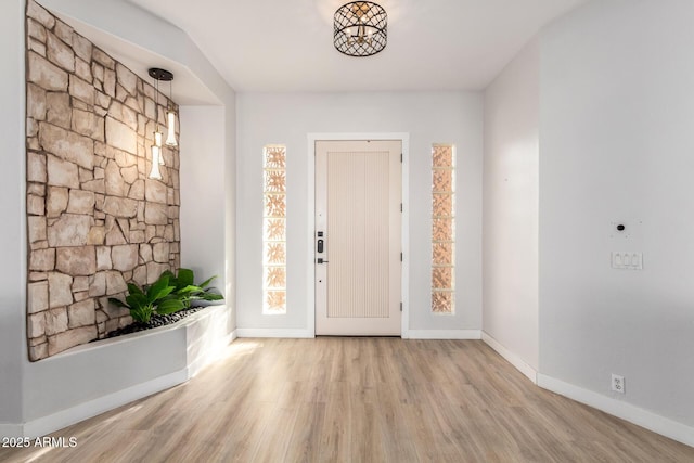 entryway featuring light wood finished floors, a wealth of natural light, and baseboards