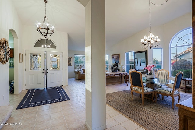 foyer entrance featuring a chandelier, light tile patterned floors, and high vaulted ceiling