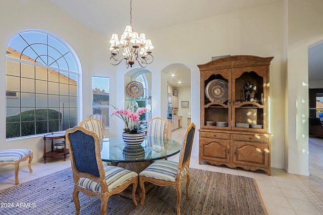 tiled dining area featuring high vaulted ceiling and a notable chandelier