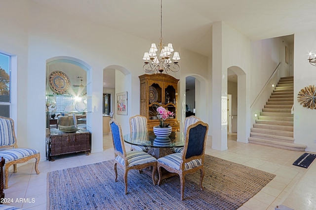 tiled dining area featuring a towering ceiling and an inviting chandelier