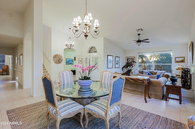 tiled dining area with high vaulted ceiling and ceiling fan with notable chandelier