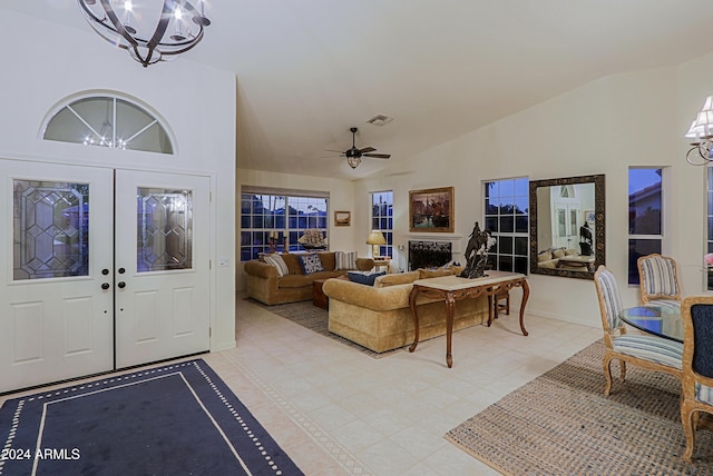 foyer entrance featuring french doors, ceiling fan with notable chandelier, and high vaulted ceiling