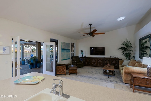 living room with ceiling fan, french doors, light colored carpet, and vaulted ceiling