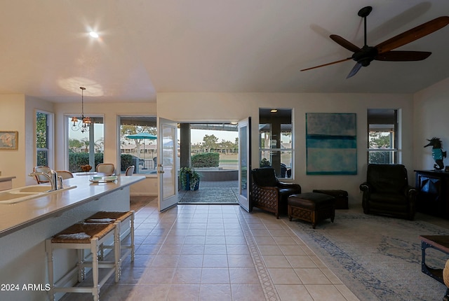 interior space featuring french doors, ceiling fan with notable chandelier, a healthy amount of sunlight, and sink