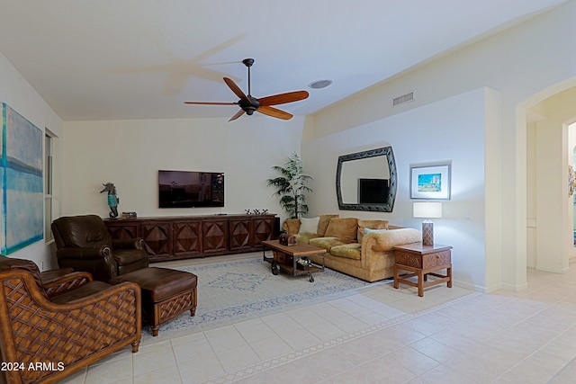 living room featuring lofted ceiling, ceiling fan, and light tile patterned floors