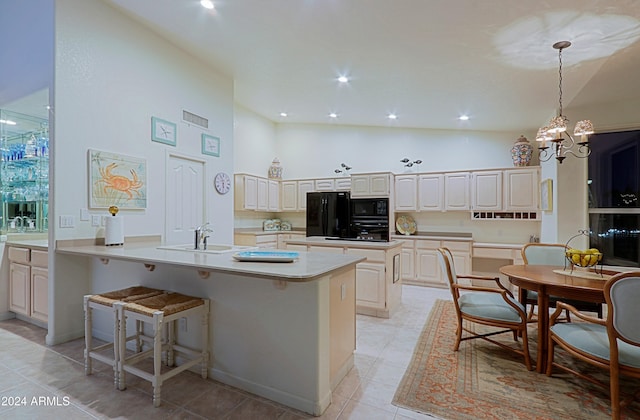 kitchen with sink, a chandelier, decorative light fixtures, a breakfast bar, and black appliances