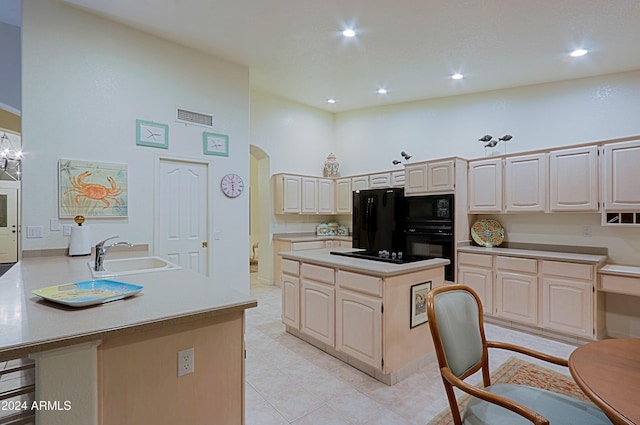 kitchen featuring a center island, sink, kitchen peninsula, a towering ceiling, and black appliances