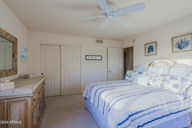 carpeted bedroom with ceiling fan and a closet