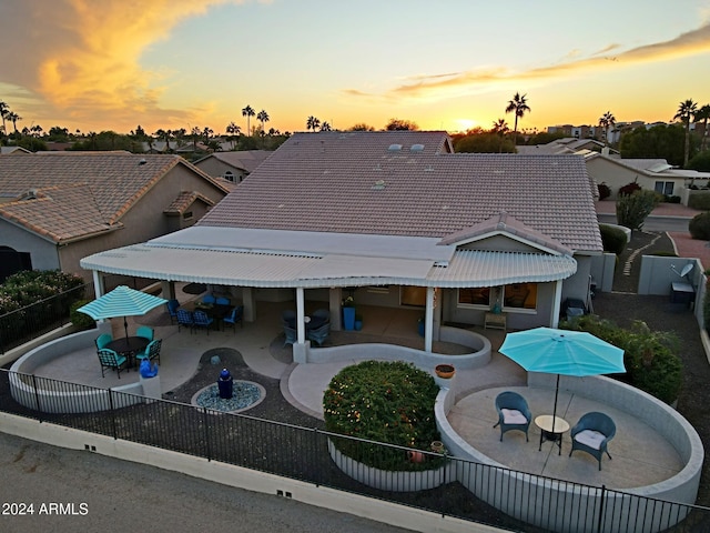 back house at dusk with a patio