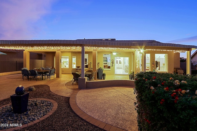 back house at dusk featuring outdoor lounge area and a patio