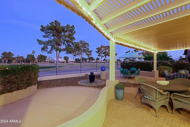 patio terrace at dusk featuring a pergola