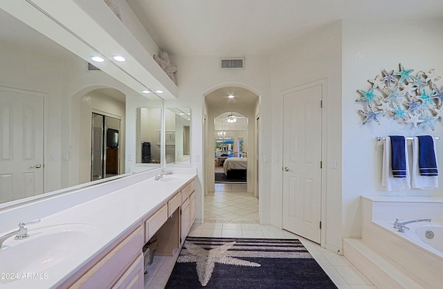 bathroom featuring tile patterned flooring, vanity, and a washtub