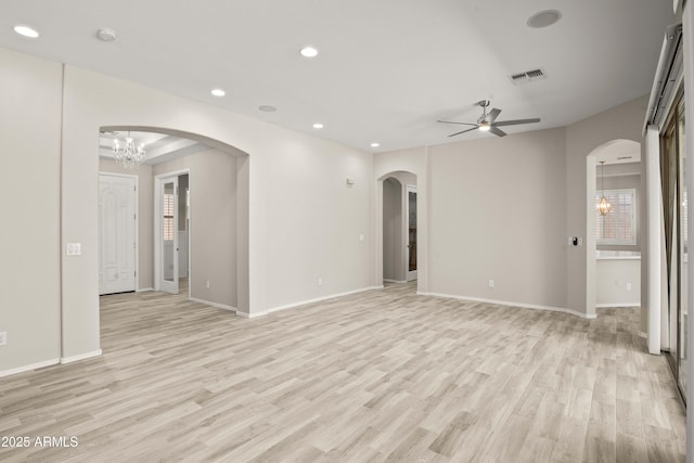 unfurnished living room with a chandelier, light wood-style flooring, arched walkways, a ceiling fan, and recessed lighting