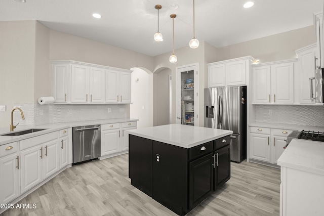 kitchen with a sink, appliances with stainless steel finishes, dark cabinets, white cabinetry, and recessed lighting