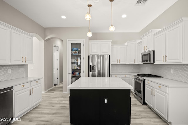 kitchen with appliances with stainless steel finishes, white cabinetry, light countertops, tasteful backsplash, and recessed lighting
