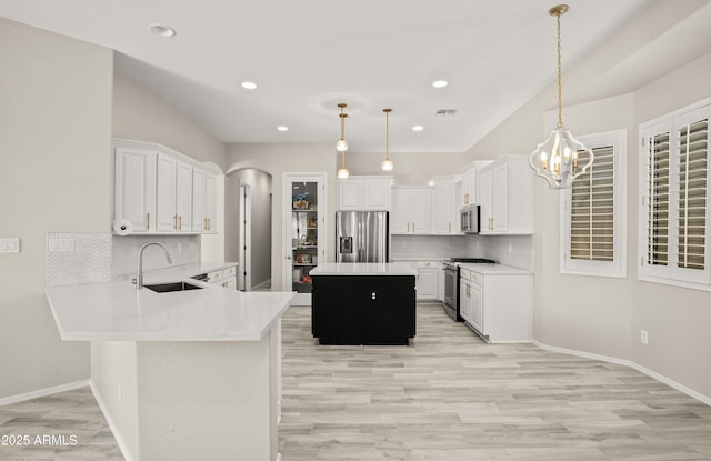 kitchen featuring stainless steel appliances, a sink, light wood-style floors, decorative backsplash, and recessed lighting
