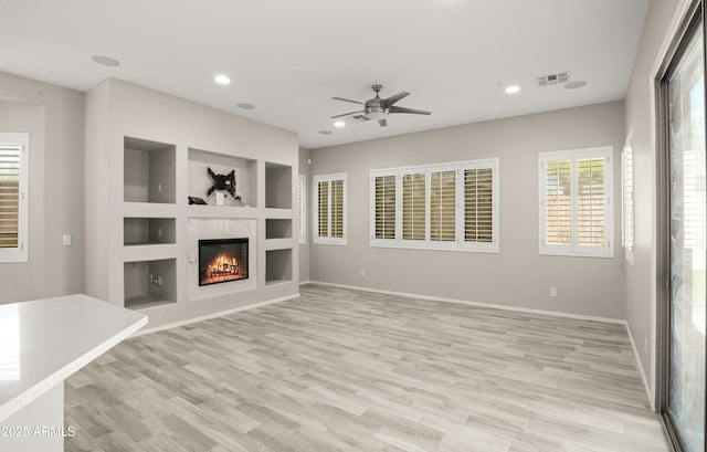 unfurnished living room featuring a ceiling fan, a fireplace, light wood-style floors, recessed lighting, and baseboards