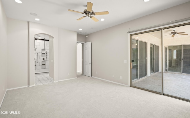 unfurnished bedroom featuring access to exterior, arched walkways, carpet floors, recessed lighting, and baseboards