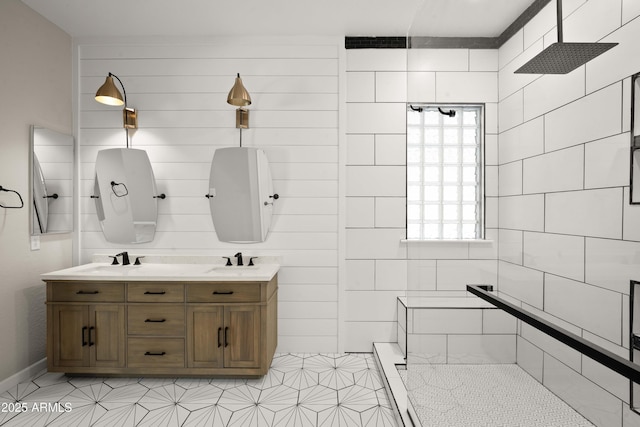 full bathroom with plenty of natural light, tiled shower, and double vanity