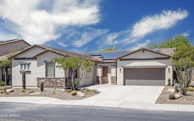 view of front of property featuring an attached garage, roof mounted solar panels, concrete driveway, stucco siding, and stone siding