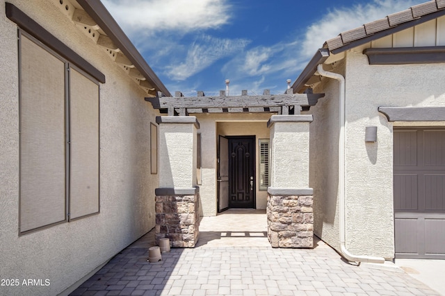 view of exterior entry with stucco siding