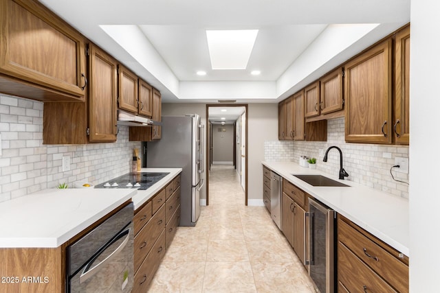 kitchen with sink, wall oven, black electric stovetop, stainless steel dishwasher, and beverage cooler